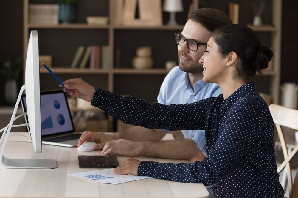 duas pessoas observando um computador