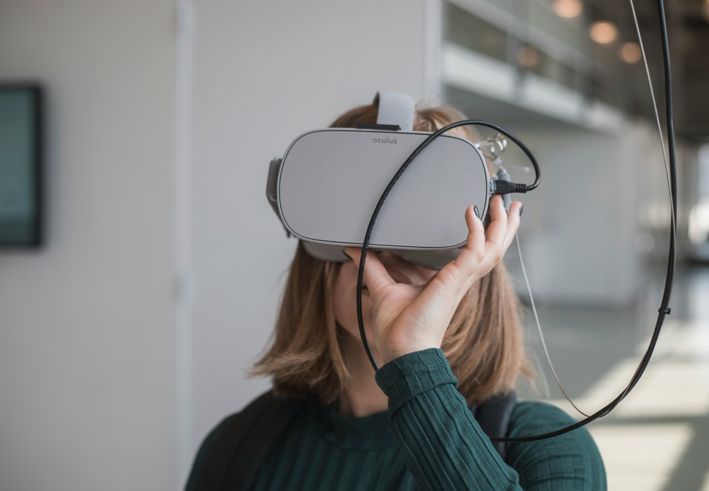 mulher utilizando um óculos virtual, o qual é um exemplo de uma nova tecnologia