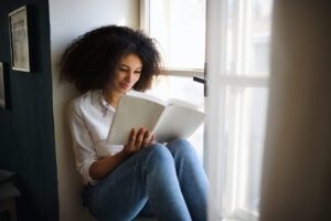mulher sorrindo e lendo um livro