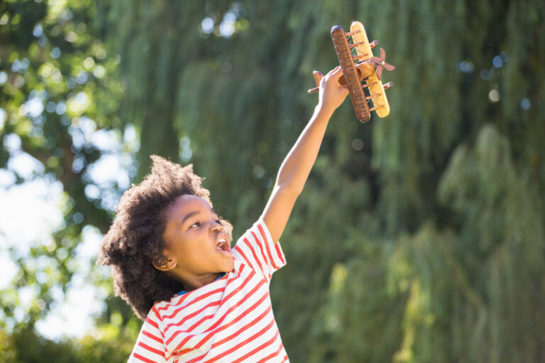 criança brincando com invenção de papelao