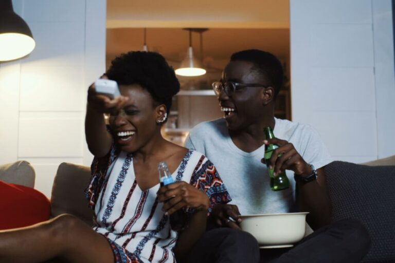 casal sorrindo assistindo filme na tv